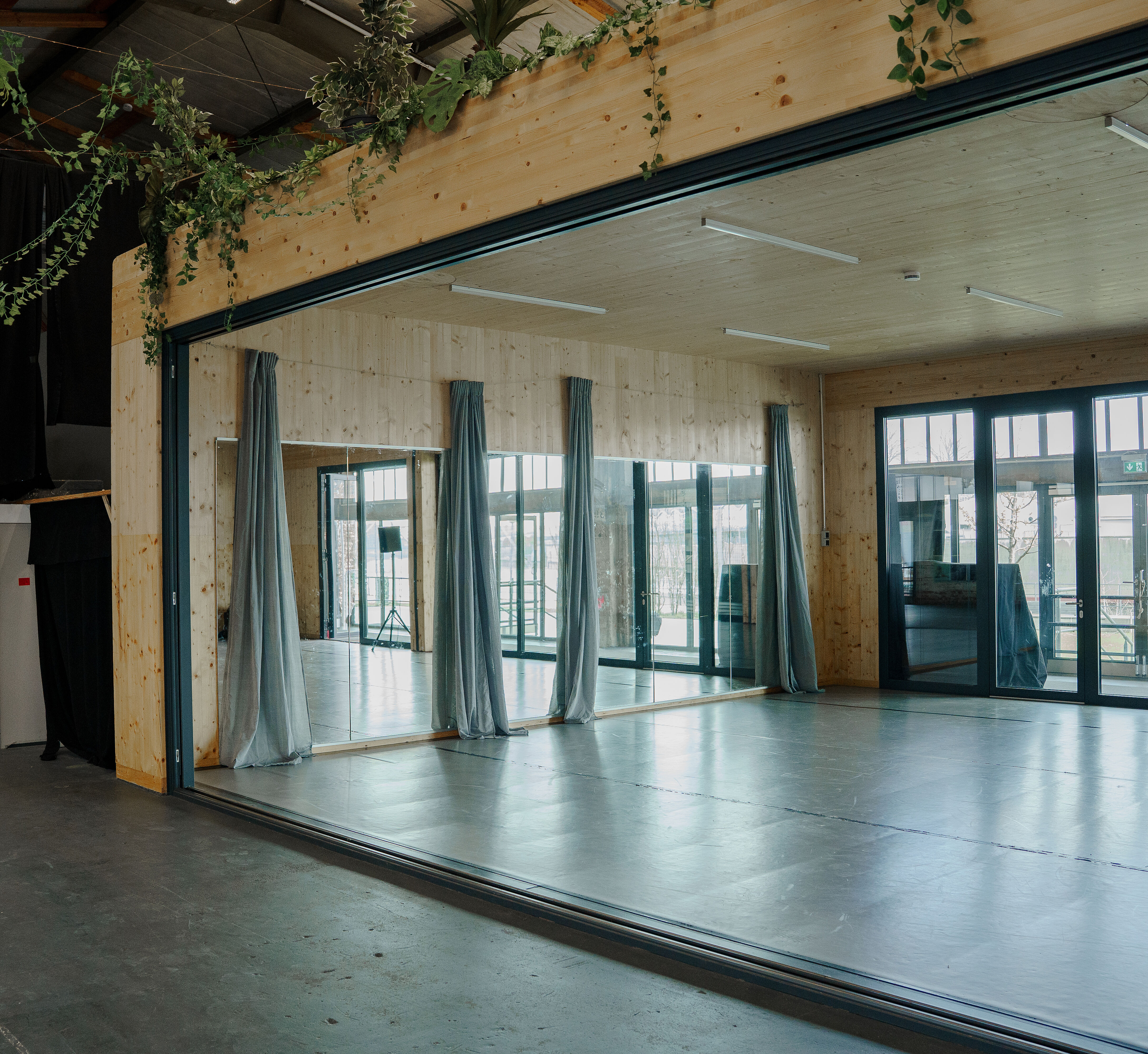 Blick vom Foyer aus auf die Spiegelwand des Tanzsaales. Die Vorhänge sind zur Seite gezogen.